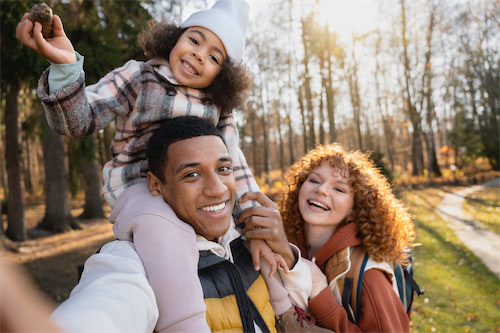 A young family is playing in the park after being refreshed by an IV Treatment.